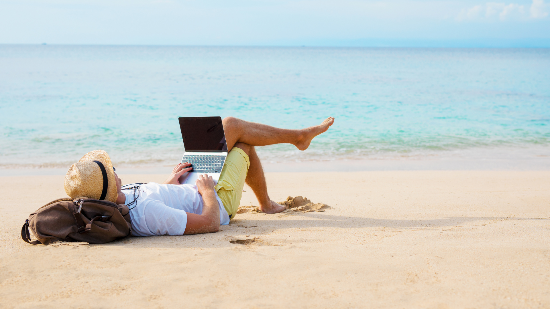 Trabajando desde la playa con un ordenador portatil